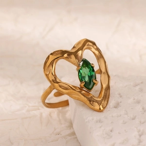 Dettaglio macro dell'anello dorato regolabile con pietra marquise verde e cuore martellato