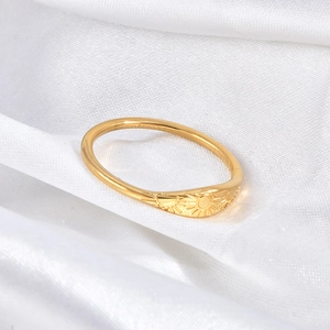 Detail of vintage gold stainless steel ring with sunburst pattern on silk background