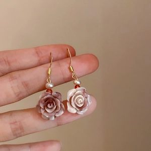 Dettaglio ravvicinato di orecchini a rosa con petali sfumati e perle d'acqua dolce
