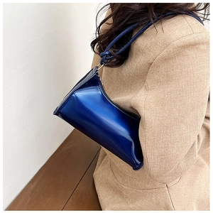 Detail of bright blue patent leather baguette bag with high gloss finish and slim strap