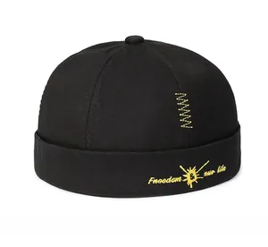 Detail of yellow embroidery on black cotton docker hat with freedom lettering