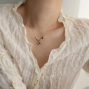 Detail of vintage velvet tiger eye stone pendant necklace on woman's collarbone