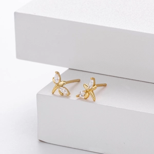 Macro detail of gold butterfly stud earrings with marquise-cut clear zircons