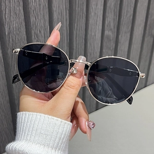 Detailed close-up of retro round silver metal sunglasses with dark UV lenses