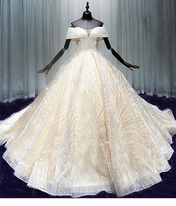 Detail of sequined off-shoulder ball gown wedding dress with intricate beadwork and luxury texture