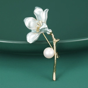 Exquisite magnolia flower brooch with pearlescent petals and white pearl on gold stem