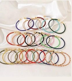 Detail of colorful braided silk cords with gold metal ends for DIY jewelry making
