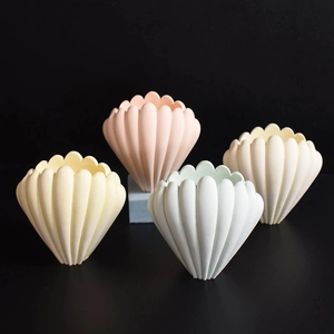 Dettaglio di vasi decorativi a forma di conchiglia rigata in rosa, giallo e bianco