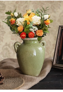 Detail van vintage keramische vaas met craquelé glazuur, rustieke handvaten en bloemen