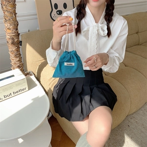 Blue corduroy drawstring storage pouch with Sozakka label held by a female model