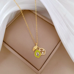 Detail of gold titanium necklace with sparkling zircon fruit pendant and white pearl