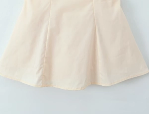 Detail of off-white mini dress hemline featuring smooth fabric and clean A-line stitching