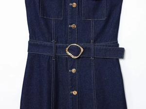 Detailed view of dark blue denim dress featuring gold buttons and irregular textured metal buckle