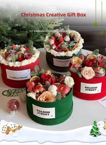 Detail view of round velvet Christmas gift boxes with roses, strawberries, and pine cones