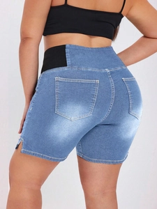 Detail view of high-waisted denim shorts featuring black elastic waistband and lifting cut