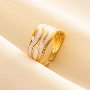 Detailed macro view of gold adjustable ring with white enamel marble texture on satin