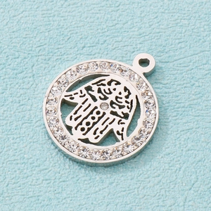 Macro view of silver hamsa hand pendant with sparkling zircon border detail