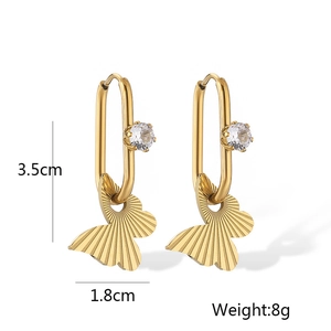 Detail of gold bow earrings featuring a round clear gemstone measuring 3.5cm by 1.8cm