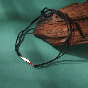 Close-up of Palestine map pendant on a black braided rope bracelet with enamel detail