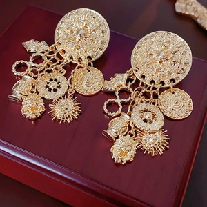 Nahaufnahme goldener Vintage-Ohrringe mit Sonnen-, Münz- und Löwenkopf-Anhängern