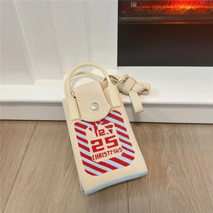 Detail of beige knitted mini Christmas bag featuring red stripes and December 25 text