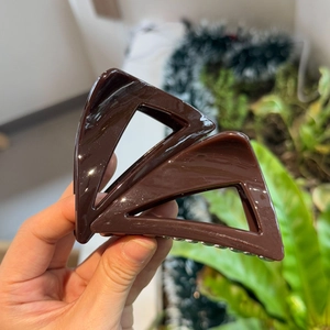 Detailed close-up of dark brown triangular hair claw clip made of durable resin material