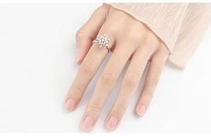 Close-up of adjustable silver snowflake ring with clear crystals on a finger