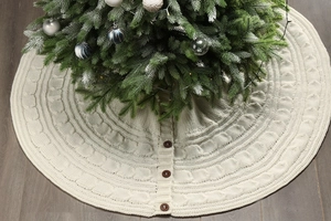 Detail of ivory cable-knit Christmas tree skirt with decorative wooden buttons