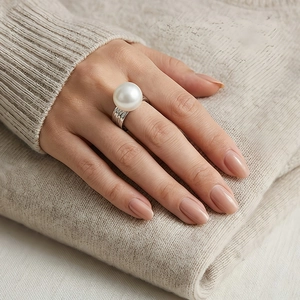 Detailed close-up of a large white pearl ring with textured silver stainless steel band