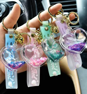 Colorful heart-shaped liquid quicksand shaker keychains with bells for bags and keys.