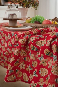 Detailed texture of red cotton linen tablecloth with gingerbread man and Christmas patterns