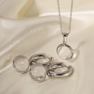 Détail du collier et boucles d'oreilles en argent avec globes en verre sur soie