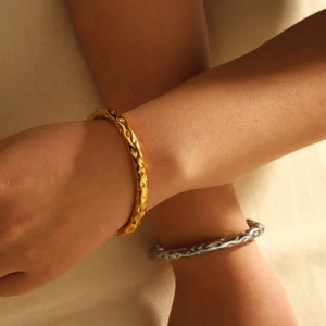 Detailed view of gold and silver lava hammer pattern stainless steel C-shaped cuff bracelets