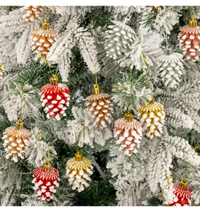 Gros plan d'ornements de Noël en forme de pomme de pin sur des branches enneigées