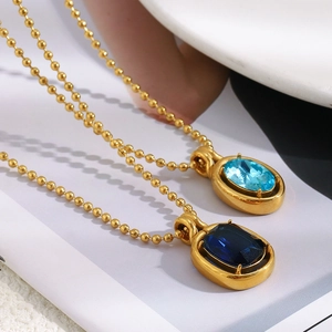 Detail of 18K gold-plated beaded necklaces with light and dark blue oval gemstones