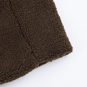 Close-up of deep brown sherpa fleece fabric showing soft curly texture and thick material