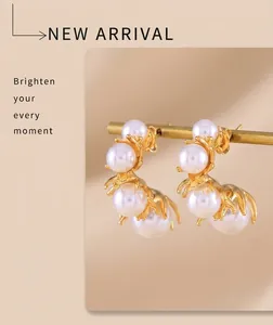 Detail showing four white pearls set in a gold-plated C-shaped titanium steel earring