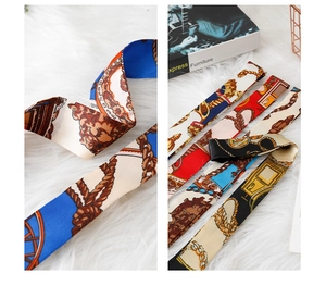 Detailed view of various silk scarves featuring vintage chain patterns on plush background
