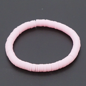 Detailopname van roze heishi polymeerklei kralenarmband op donkere achtergrond