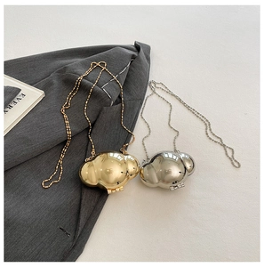 Detailed view of mini metallic shell bags in gold and silver with elegant ball chain straps