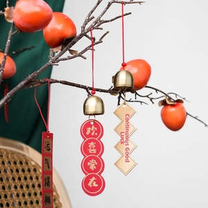 Traditional brass bells hanging with red tassels and decorative Chinese tags for home decor