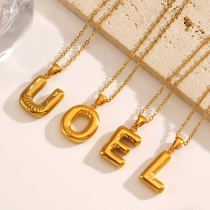 Puffy balloon alphabet pendants in gold finish with delicate cable chains shown from a 45-degree angle