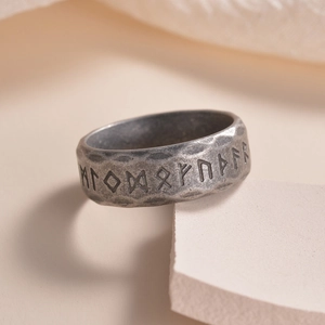 Gros plan d'une bague runique viking en argent antique sur fond de pierre