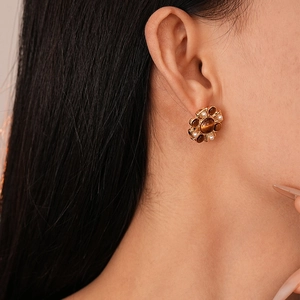 Retro flower earrings with brown cat-eye stone and small pearls on model ear