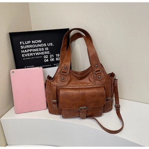 Detail of vintage brown tote bag with magnetic buckles and metal zippers for daily work