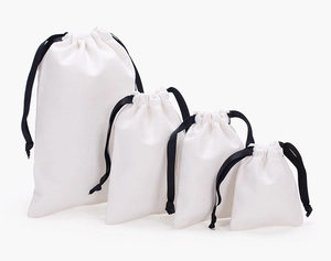 Four different sizes of white cotton drawstring gift bags with black cord stoppers