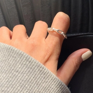 Minimalist silver chain link ring on finger featuring oval interlocking loops