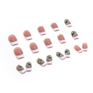White French press-on nails with butterfly art, pearls, and crystals on a nude base
