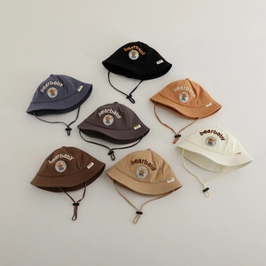 Flat lay of colorful baby bear bucket hats with adjustable chin straps and embroidery