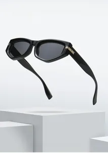 Detail view of black cat-eye sunglasses with golden metal hinges on stone stand